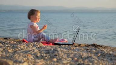 小女孩坐在海边的笔记本上。 把工作和假期结合起来的新一代人。 创造力和创造力